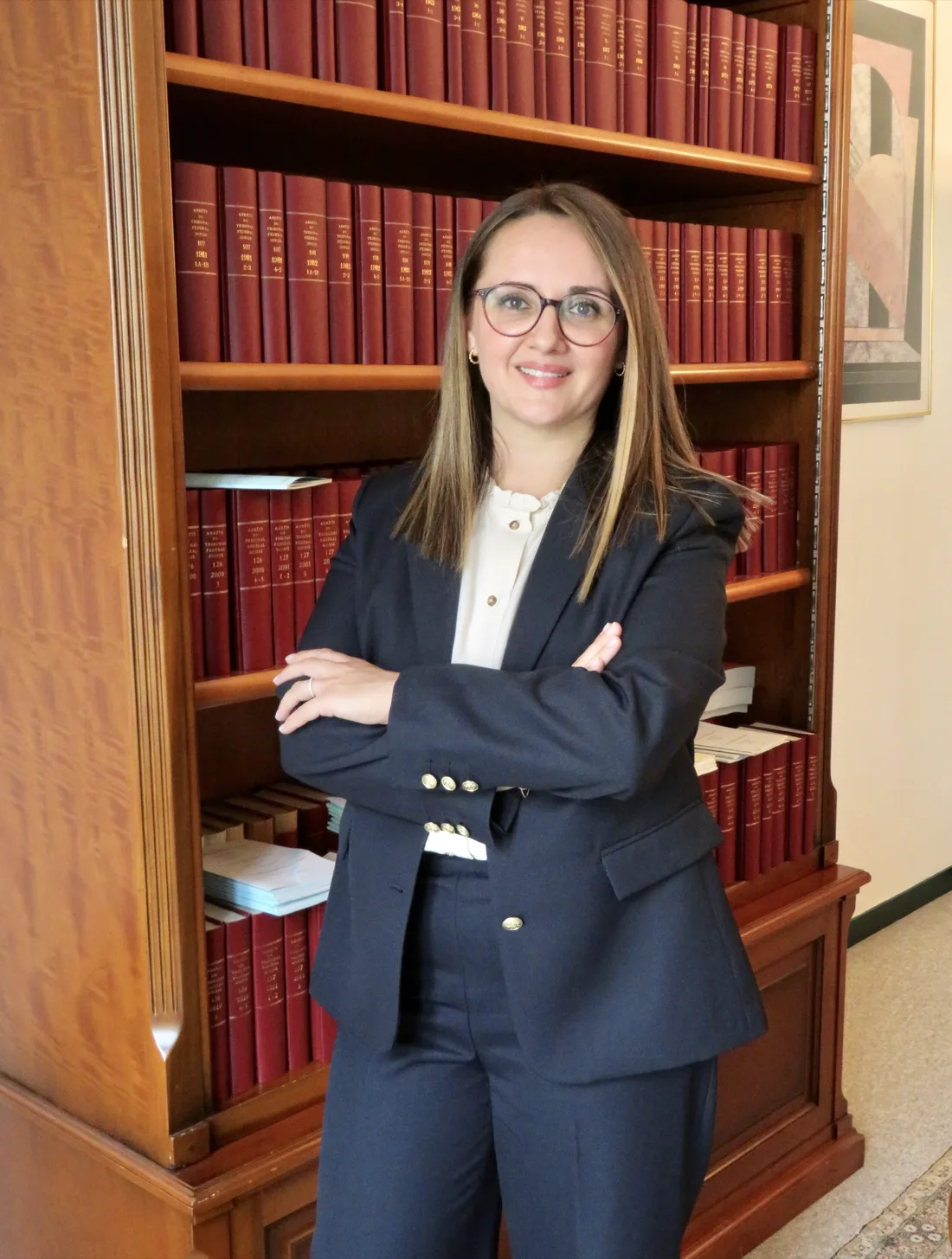 Me Samra Husakovic-Gadouar, avocate, devant une bibliothèque juridique